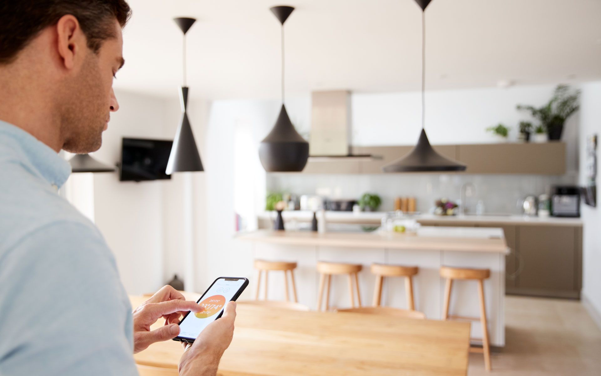 Mann steuert Smart Home mit Smartphone